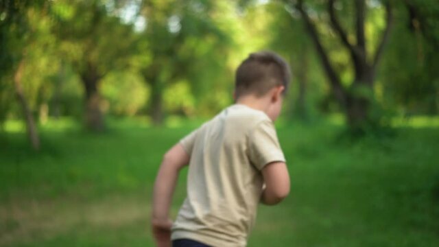 Child Smiles With an Antistress Toy and Takes Step Back. Slow Motion Video of Child Walking Away with toy in Hand. Kid Holding Rainbow Pop It Fidget Toy. High quality 4k footage