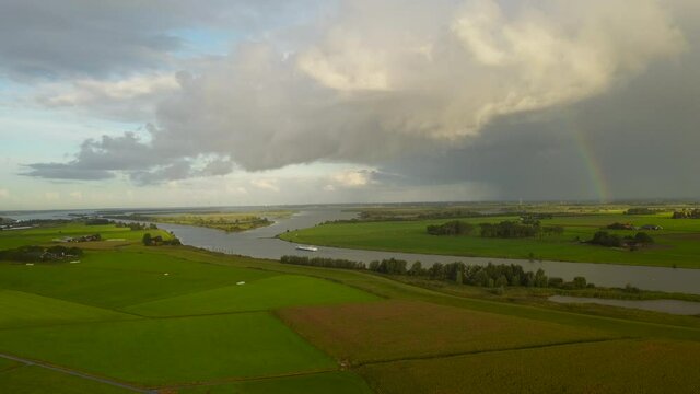 Storm clouds and a rainbow in the distance over the Ijsseldelta in Overijssel, The Netherlands.
