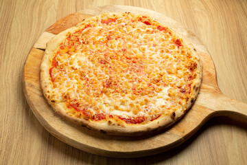 Traditional margherita pizza on rustic wood background.