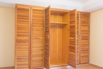 solid wood wardrobe with six doors in empty parquet floored room