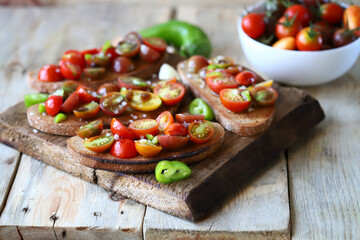 Croutons with cherry tomatoes, garlic and hot peppers. Healthy bruschetta with tomatoes.