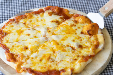 Homemade Pizza made from dough topped with spices like ham, sausage , vegetables and cheese