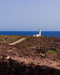 Fototapeta premium View of lighthouse in the scenic lava rock cliff, Linosa