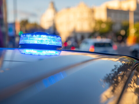 Fototapeta blue lights on the roof of a police car with the background out of focus and lights with bokeh effect  