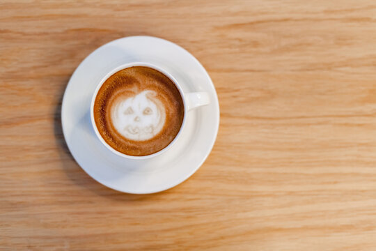 Halloween coffee with picture pumpkin on wooden table. Holiday latte art.