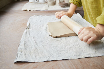 Female ceramist working in pottery studio. Ceramist's Hands Dirty Of Clay. Process of creating pottery. Master ceramist works in her studio
