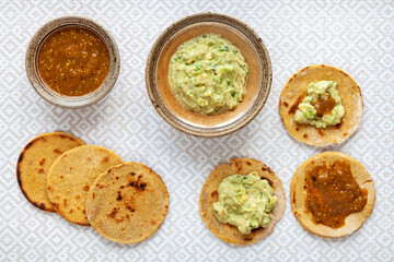 Avocado with tahini and greek yogurt sauce with roasted tomatillo salsa on corn roti flatbread.