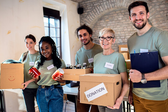 Portrait of volunteers with working in community charity donation center.