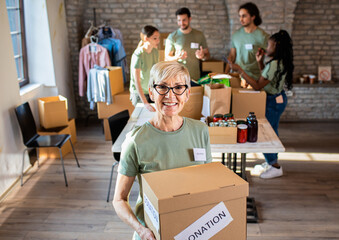 Portrait of senior female volunteer holding a box with donation.