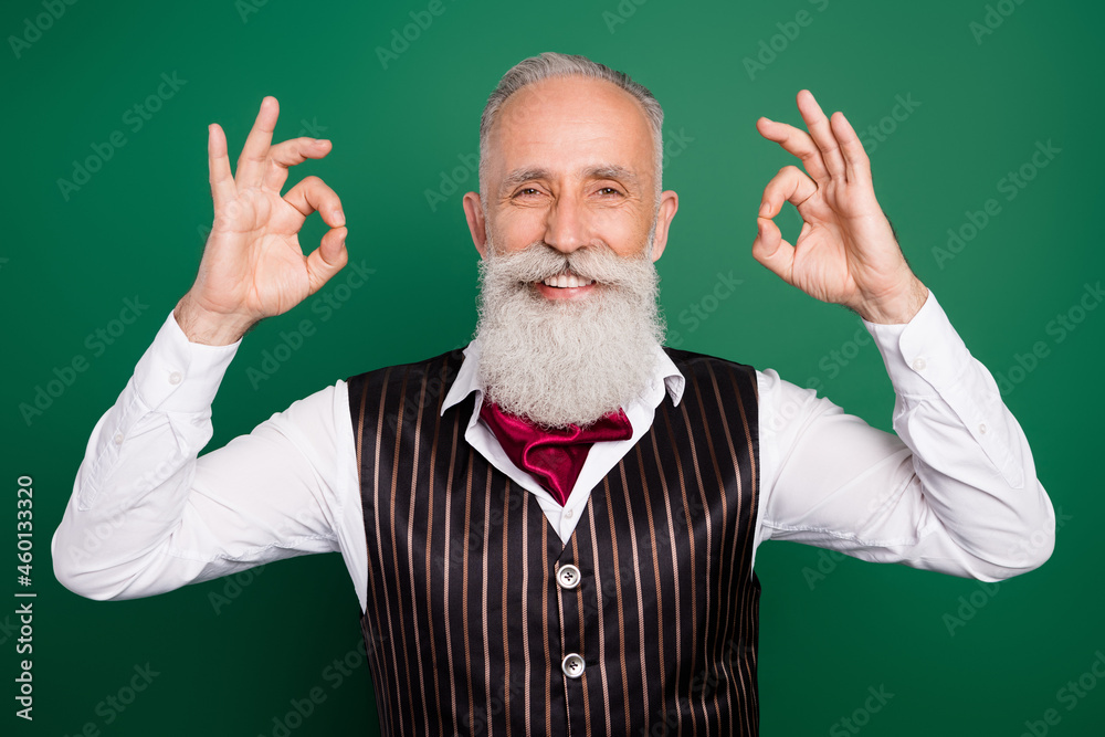 Sticker Photo of bearded promoter reliable mature man show okey signs wear striped suit scarf on green color background