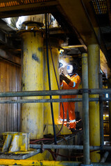 Welder weld gas pipe casing in offshore oil and gas platform rig.