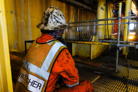 Fire watcher watch welder weld gas pipe casing for stop work in case of gas explosive, working in offshore oil and gas platform rig.