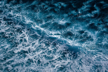 Aerial view to seething waves with foam. Waves of the sea meet each other during high tide and low tide