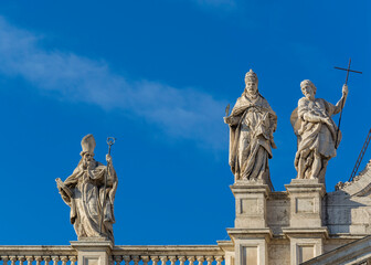 Statues on the roof of the Papal Archbasilica of St. John in Lateran (Basilica di San Giovanni in Laterano) in a sunny day, Italy, Rome