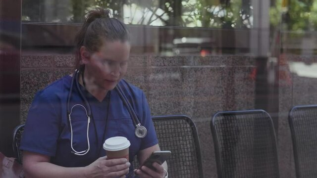 Slow Motion Of Nurse Using Phone In Covered Bus Stop