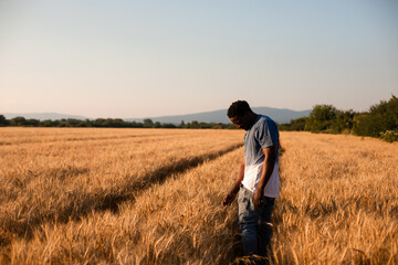 Naklejka na ściany i meble Young farmer standing in the middle of the field