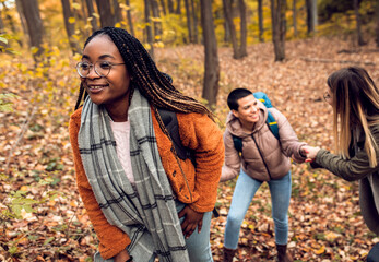 Three female friends enjoying hiking in forest.