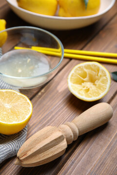 Citrus reamer and fresh lemons on wooden table