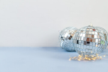 Disco ball against white and light blue background with empty space for text 
