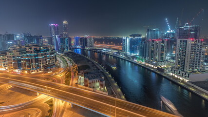 Fototapeta premium Skyscrapers at the Business Bay aerial night timelapse in Dubai, United Arab Emirates