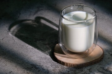 a glass of milk cup and its shadow in the light