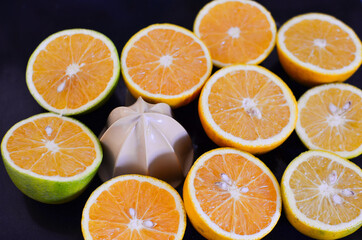 laranjas partidas ao meio e uma pe&ccedil;a de espremedor 