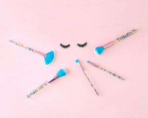 Creative concept with makeup brushes and eyelashes. Minimal makeup background.