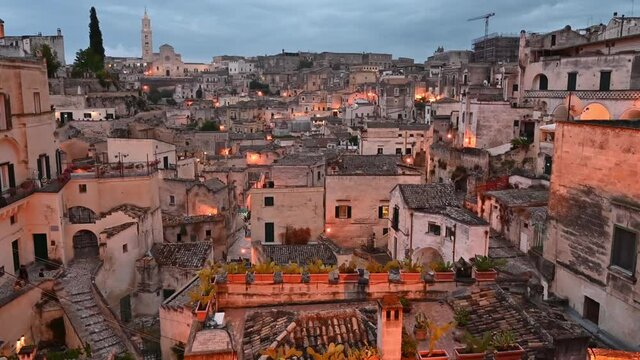 Matera, Basilicata, Italy.August 2021. Pan footage at blue hour with wide angle lens in the direction of the Sassi of Matera. Chaotic arrangement of the houses, in the background the cathedral.