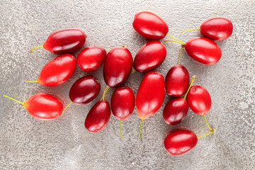 Several bright red ripe dogwood berries  on a metal tray, close-up, top view.