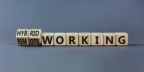 Hybrid or remote working symbol. Turned wooden cubes and changed words 'remote working' to 'hybrid working'. Beautiful grey background. Business, hybrid or remote working concept, copy space. - obrazy, fototapety, plakaty