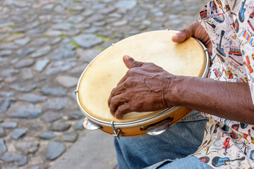 Brazilian samba performance with musician playing tambourine in the streets of Pelourinho, city of Salvador, Bahia - obrazy, fototapety, plakaty
