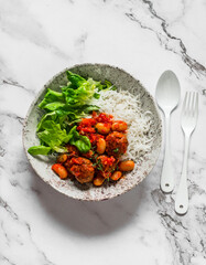 Balanced lunch - meatballs with beans stewed in tomato sauce with rice and fresh green salad on a light background, top view