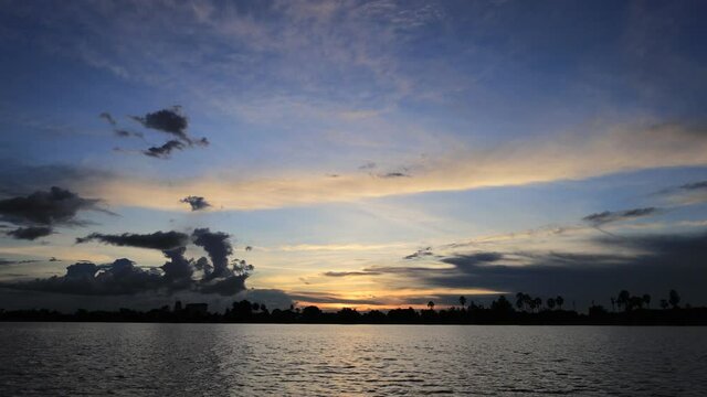 Time-lapse photography of evening sky, red, orange, yellow clouds over the river