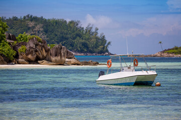 Boat on the shore of a tropical island. Pleasure boat moored on the shore of the resort. Beautiful...