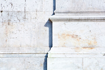Base of the marble columns with white stone frame of a romanesque Italian church