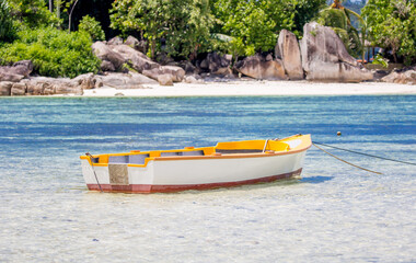 Naklejka na ściany i meble Boat on the shore of a tropical island. Pleasure boat moored on the shore of the resort. Beautiful tropical landscape of the Seychelles.