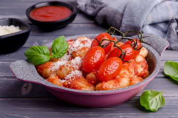 Gnocchi with tomatoes, red sauce, cheese and basil leaves
