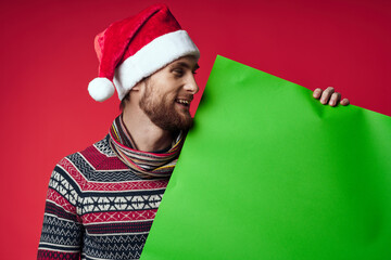 Cheerful man in a santa hat holding a banner holiday isolated background