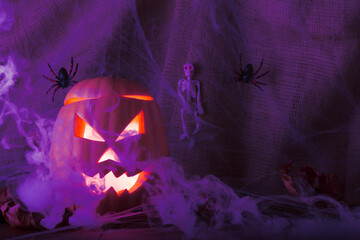 Halloween traditional holiday. Pumpkin jack lantern with glowing eyes, blue smoke