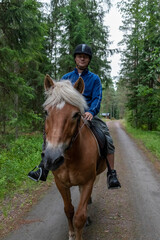 Man horseback riding in forest