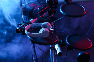 Modern electronic drum kit with headphones on dark background, color toned. Musical instrument