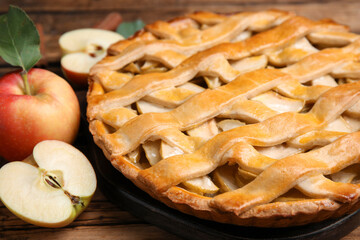 Delicious traditional apple pie on wooden table, closeup