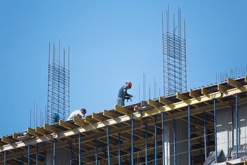Engineer technician watching team of workers on high steel platform