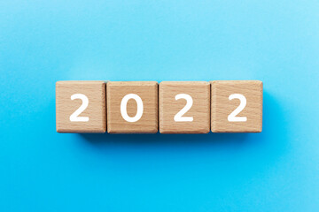 2021 text on wooden cubes on blue background. Beginning of the New Year. Copy space. Business...