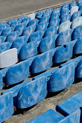 Rows of stadium grandstand seat. Rusty plastic blue and white stadium seat. Blue chairs in old stadium.