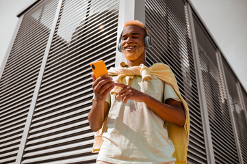 A dark-skinned bearded young man in headphones