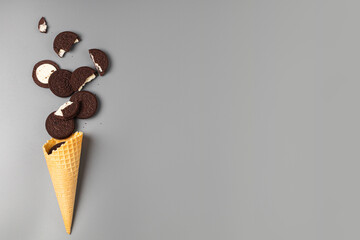 Ice cream cone with chocolate chip cookies with filling on gray background