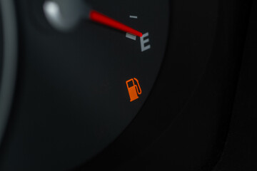 Naklejka premium Empty fuel tank indicator close up view on modern car dashboard. Fuel indicator position empty.