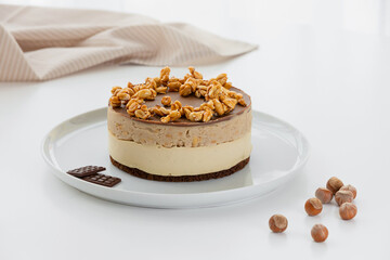 Decoration of vegetarian dessert with nuts, cake with chocolates. Ingredients: chocolate sponge...