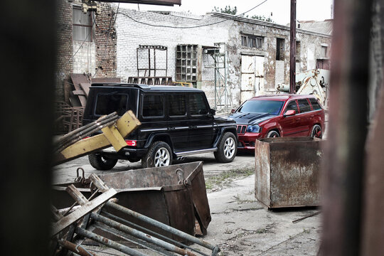 Kiev, Ukraine - September 8, 2013: Red Jeep Grand Cherokee SRT8 and Mercedes Benz G500 on the background of ruins and old buildings